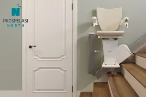 Ανελκυστήρας σκάλας για ευθύγραμμες σκάλες Prospelasi North, με μοντέρνο σχεδιασμό και λευκό κάθισμα, εγκατεστημένος σε ξύλινα σκαλοπάτια.